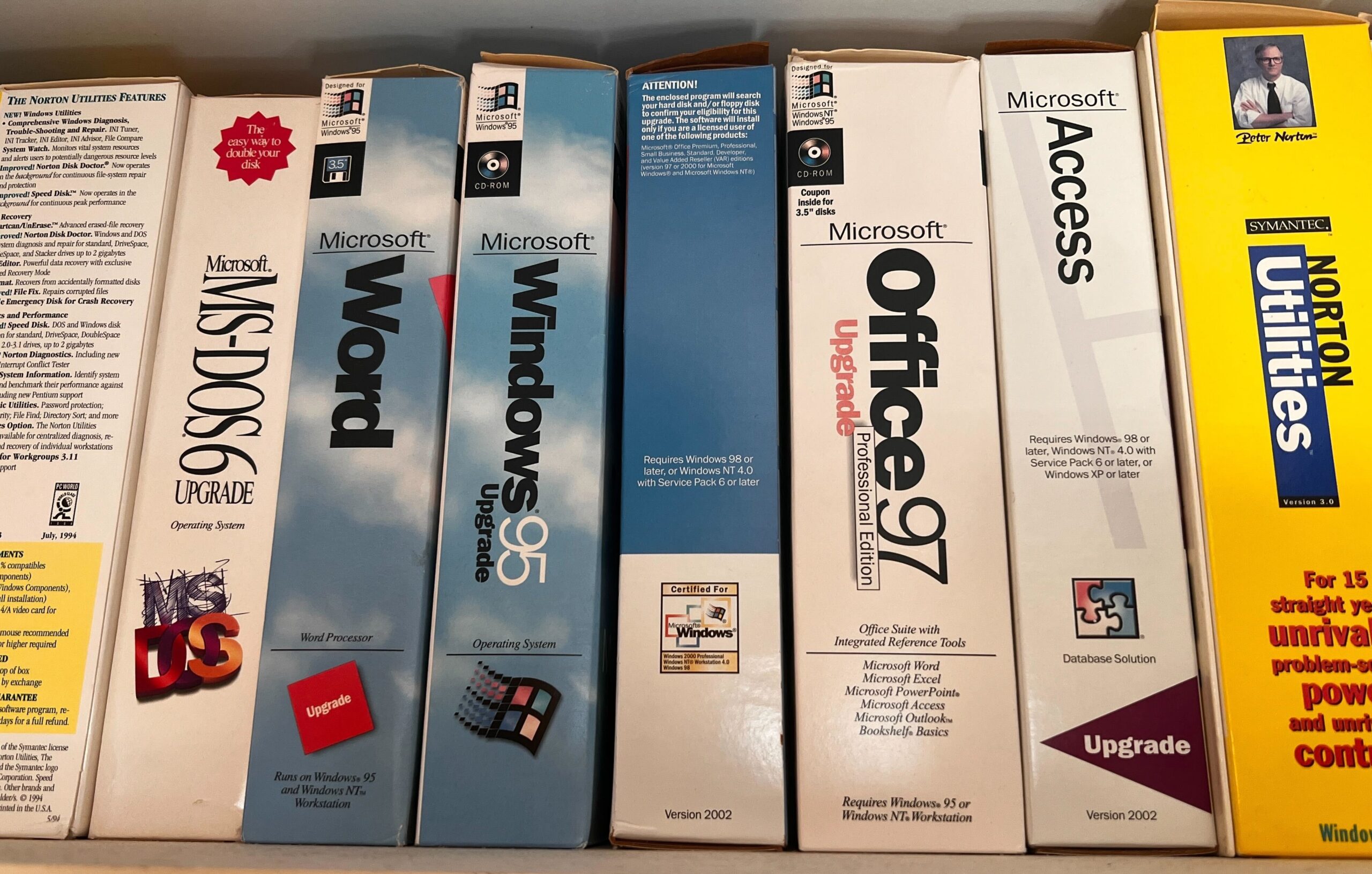 Boxed software on a shelft including MS-DOS 6, Windows 95, Office 97 and Norton Utilities