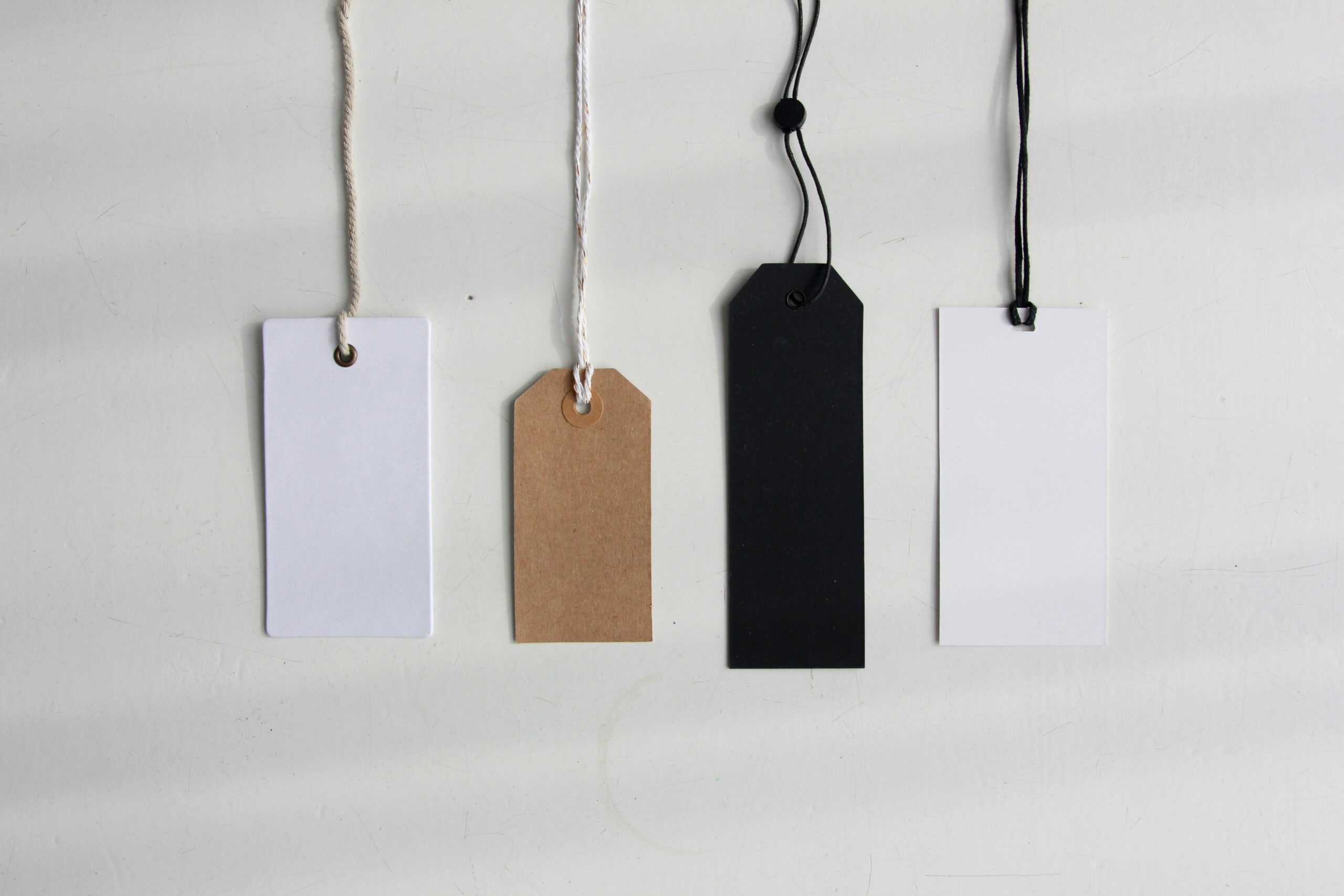 Five different tags hanging by strings.