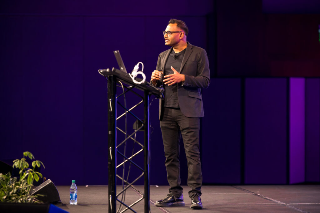 Harness CEO Jyoti Bansal speaking on stage at {unscripted} event in Boston in September 2025.